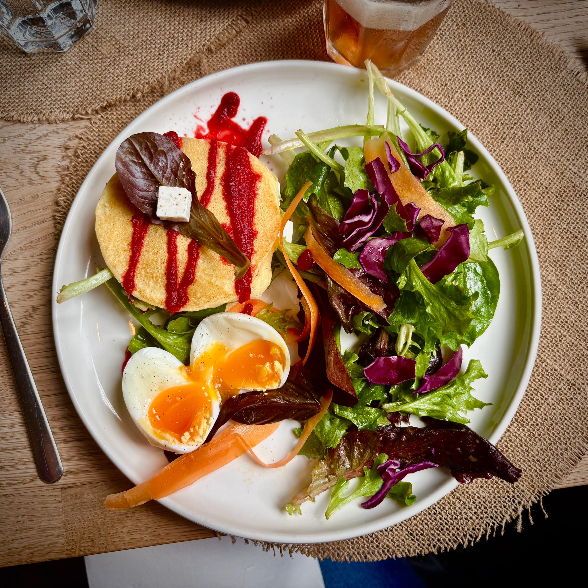 Pancake salé vu du dessus avec œuf mollet et salade colorée